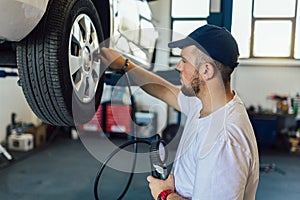 Mechanician changing car wheel in auto repair shop