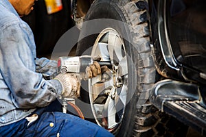 Mechanician changing car wheel in auto repair shop photo