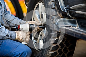 Mechanician changing car wheel in auto repair shop