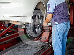 Mechanician changing car wheel in auto repair shop photo