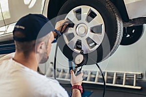Mechanician changing car wheel in auto repair service photo