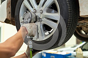 Mechanician changing car wheel in auto repair shop photo