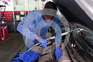 Mechanician changing filter in vehicle in the auto repair shop