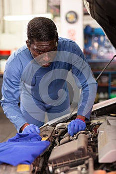 Mechanician changing filter in vehicle in the auto repair shop