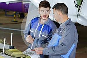 Mechanics with bag fasteners in aviation hangar