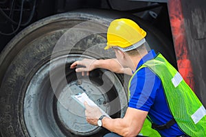 Mechanics checking wheel in cargo container. Professional technician pre-check forklift truck tires, safety concept