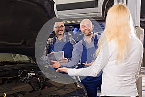 Mechanics explain car problem to owner