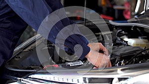 Mechanics hand check electrical wiring vehicle system in car