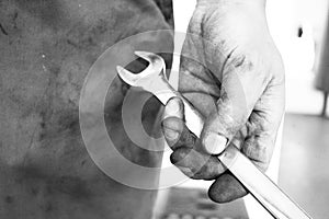 Mechanics hand holding wrench - Stock Image