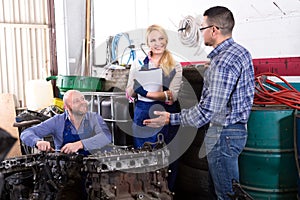 Mechanics repair engines at workshop