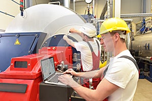 Mechanics repair a machine in a modern industrial plant - profession and teamwork