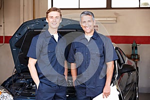 Mechanics standing in front of car