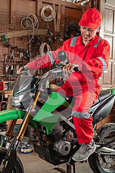 Mechanics wearing wearpacks and hats riding motorbikes while trying out a dirt bike