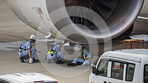 Mechanics working on Jet engine on tarmac