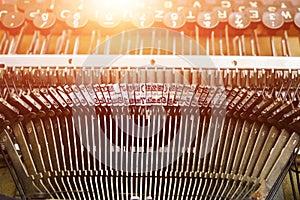 Mechanism of typesetting strikers with the English alphabet in an old retro typewriter.Solar glare photo