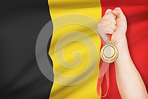 Medal in hand with flag on background - Kingdom of Belgium