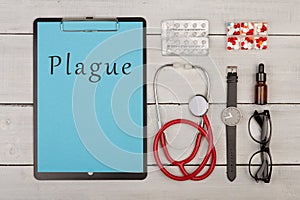 Medecine concept - clipboard with text `Plague`, pills, stethoscope, eyeglasses