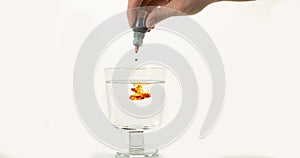 Medecine Falling into a Glass against White Background