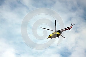 Medevac helicopter flying in blue cloudy sky. Image contains copy space photo