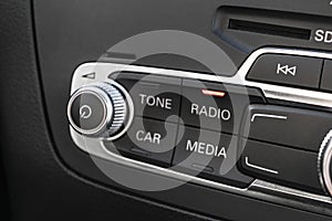 Media and navigation control buttons of a Modern car. Car interior details. Black leather interior of the luxury modern car. Moder