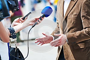 Media reporter with microphone making journalist interview for news