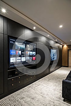 Media room. Media panel with television screens on black background