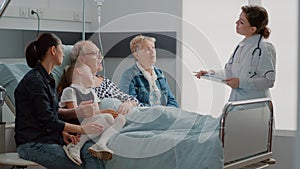 Medic explaining diagnosis to old patient and family in visit