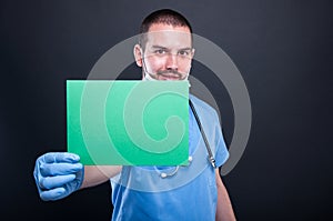 Medic holding and showing green copypsace card photo