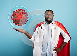 Medic like a superhero found a solution toblock the pandemic of covid19 coronavirus. Blue background photo