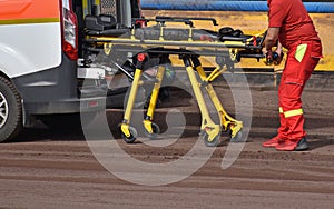 A medic pulls out the stretcher from the ambulance at the speedway track