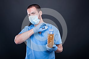 Medic wearing face mask holding bad smelling water
