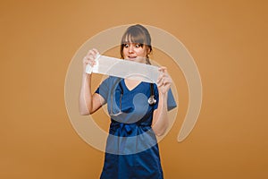 Medic woman in white coat and mask holds a twisted gauze bandage for dressing wounds, white background