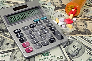 Medicaid text sign on calculator with pills and money photo