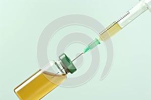 Medical ampoule with vaccine and syringe on grey background