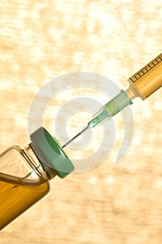 Medical ampoule with vaccine and syringe on orange background