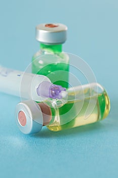 Medical ampoules with green and yellow liquid and a syringe