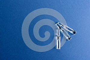 Medical ampoules with vaccine on a blue background.