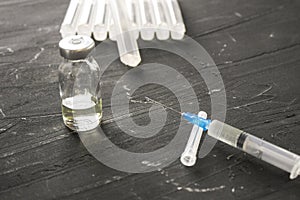 Medical ampoules with vaccine and syringe on gray background. Medical ampoules with pure vaccine and syringe on gray background