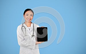 Medical App. Asian Female Doctor Showing Digital Tablet With Blank Blank Screen