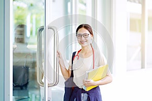 Medical Asian young female student in casual cloth holding textbooks and ready to go study in the classroom