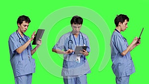 Medical assistant browsing online webpages on tablet and texting