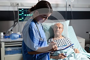 Medical assistant checking treatment of senior man