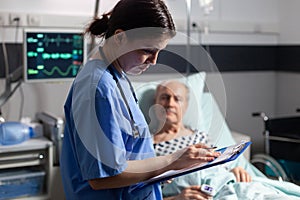 Medical assistant checking treatment of senior man