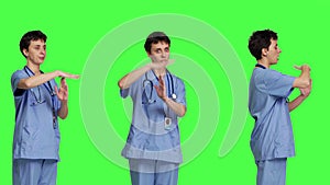 Medical assistant giving timeout symbol against greenscreen backdrop
