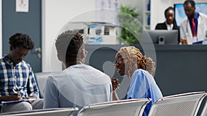 Medical assistant having conversation with patient in waiting area