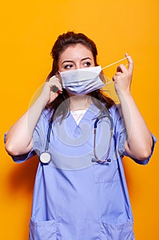 Medical assistant putting on face mask for protection