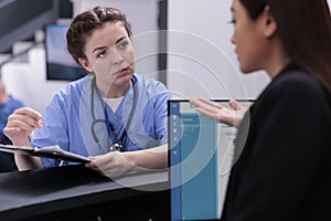 Medical assistant showing patient expertise to receptionist