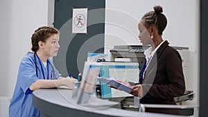 Medical assistant talking to receptionist about appointments