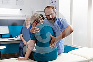 Medical assistant treating woman with back and spine pain