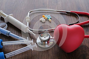 Medical background from pharmaceutical tablets and pills, stethoscope, heart and syringe.